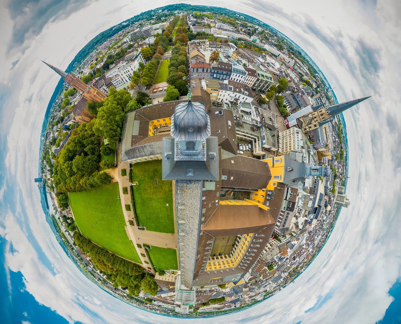 Eine Wissenschaftlerin und ein Wissenschaftler arbeiten hinter einer Glasfassade und mischen Chemikalien mit Großgeräten.