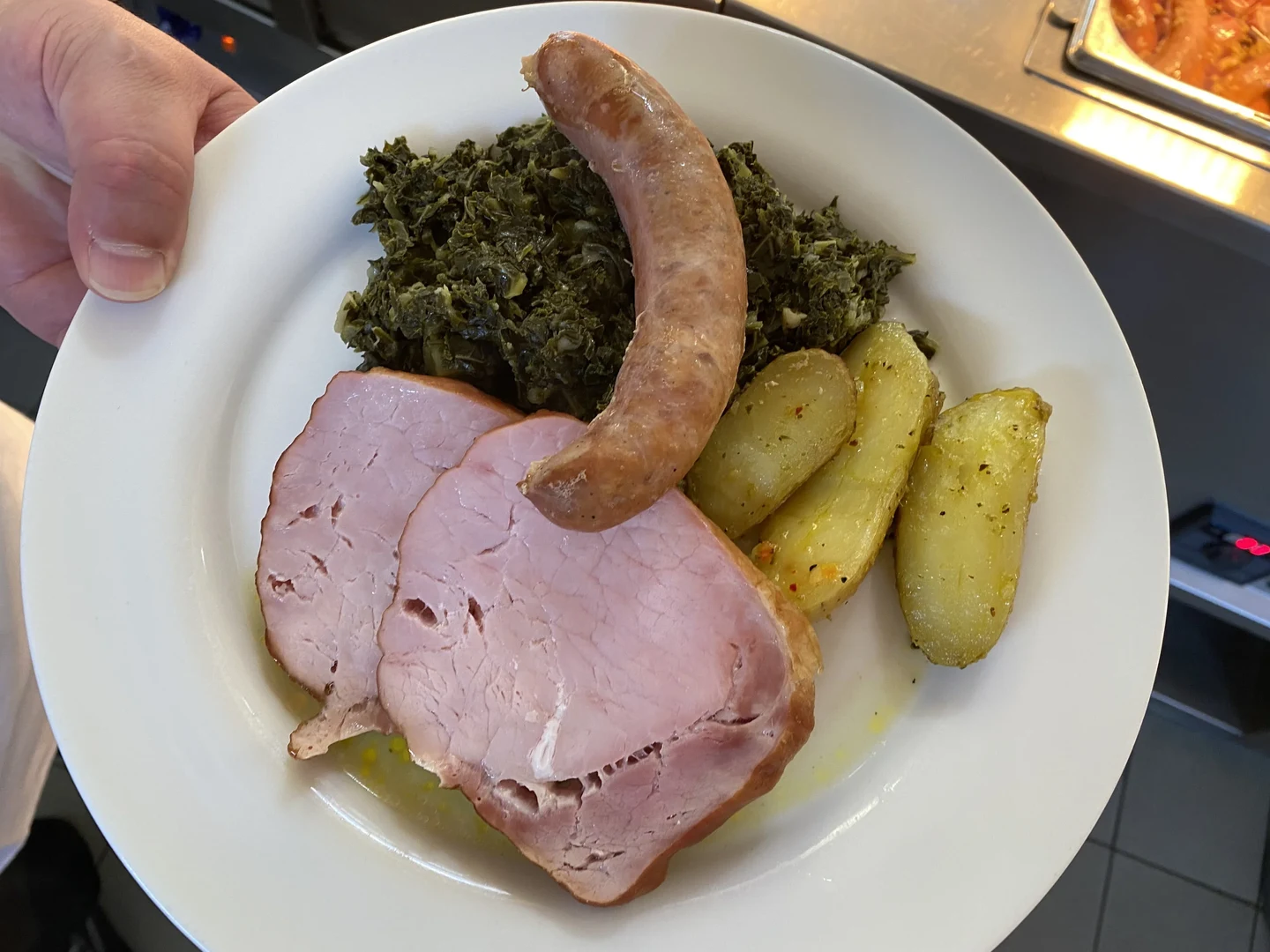 Eine Wissenschaftlerin und ein Wissenschaftler arbeiten hinter einer Glasfassade und mischen Chemikalien mit Großgeräten.