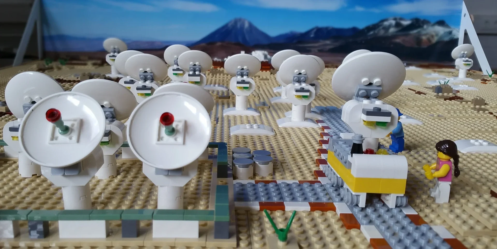 Eine Wissenschaftlerin und ein Wissenschaftler arbeiten hinter einer Glasfassade und mischen Chemikalien mit Großgeräten.