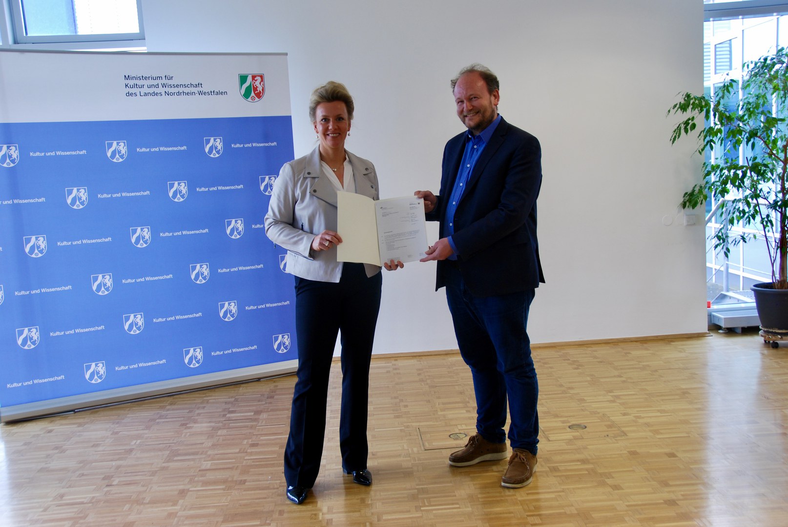 NRW-Wissenschaftsministerin Ina Brandes - übergibt den Förderbescheid stellvertretend an Prof. Dr. Klaus von Stosch.