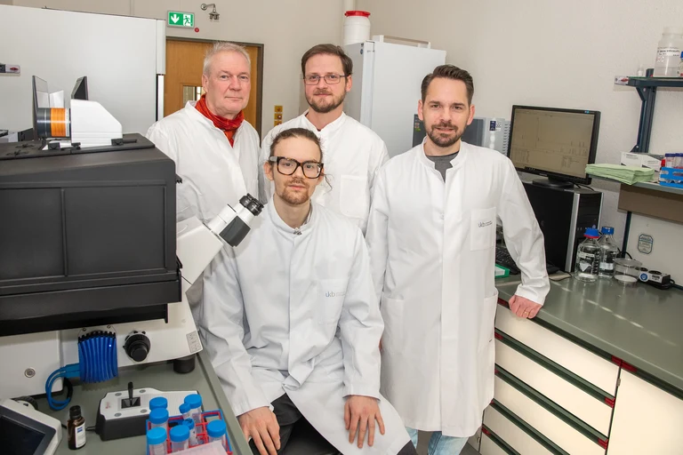 Bakterium Staphylococcus aureus unter dem Mikroskop (von l. n. r.) Prof. Ulrich Kubitscheck, Jan-Samuel Puls (vorne), Dominik Brajtenbach und Dr. Fabian Grein fanden heraus, dass eine funktionierende Peptidoglykan-Synthese, eine Kernkomponente der Zellwand, essentiell für die Zellteilung ist.
