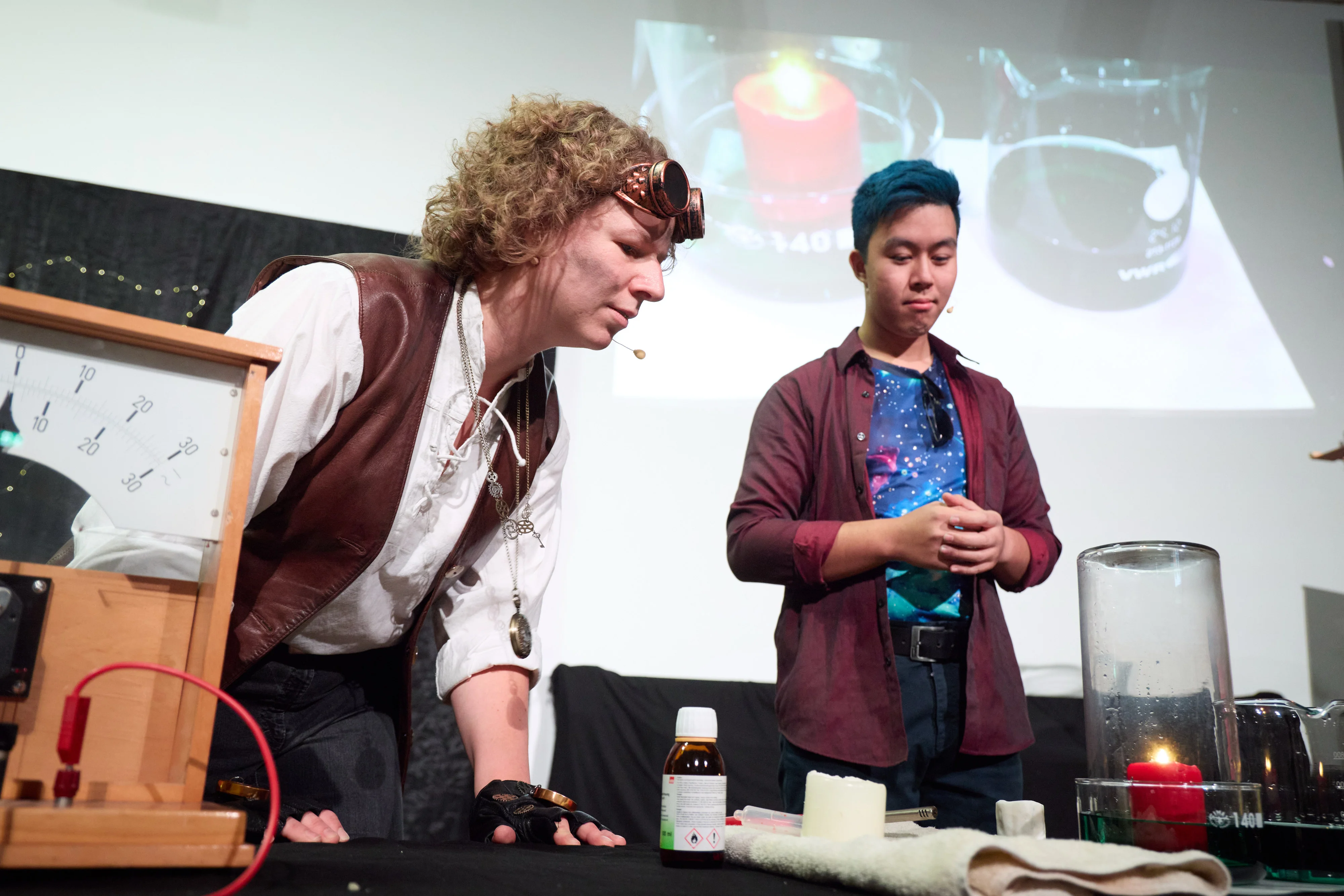 Das Universum (Tien-Son Nguyen) veranschaulicht der Menschheit (Jana Heysel) die physikalischen Hintergründe der Übersäuerung der Meere, indem es das Kohlenstoffdioxid aus einer Verbrennung in Wasser löst.