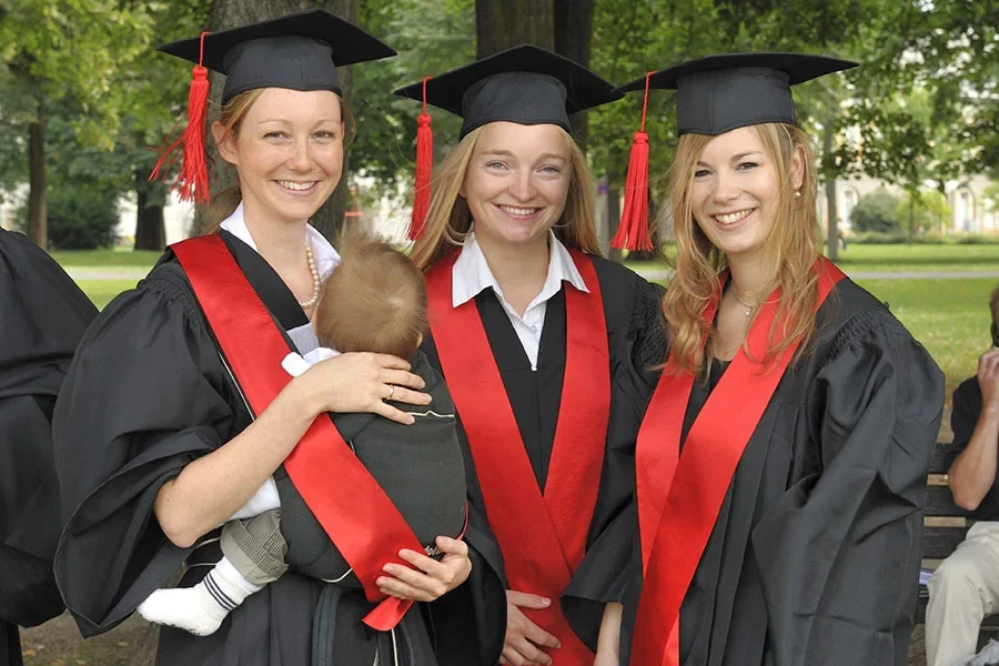 Eine Wissenschaftlerin und ein Wissenschaftler arbeiten hinter einer Glasfassade und mischen Chemikalien mit Großgeräten.