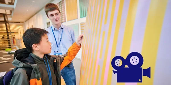 Ein Student und ein Schüler betrachten ein Bild im Arithmeum.