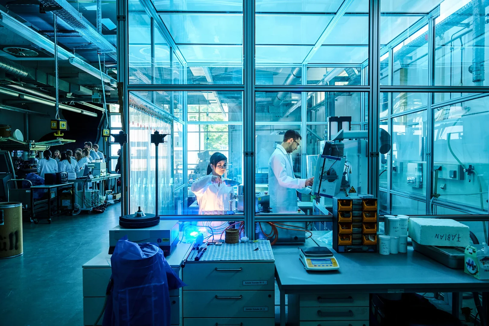 Three people in a lab doing research an testing a robot in a lab.