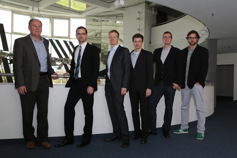 Die Projektbeteiligten vor einem Modell der ISS am Deutschen Zentrum für Luft- und Raumfahrt (DLR):