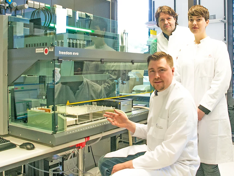 Das Forscherteam am Pipettierroboter