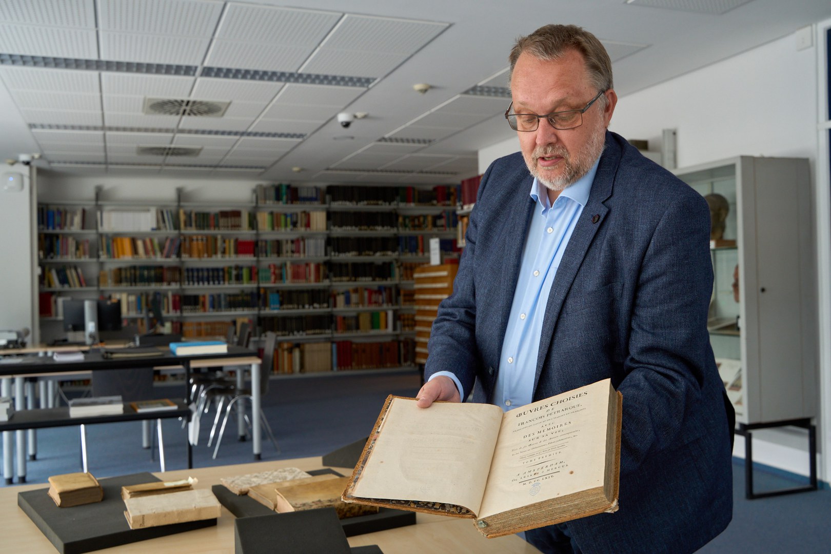 Michael Herkenhoff mit einem der 16.000 Bände aus der Bibliothek Ley.