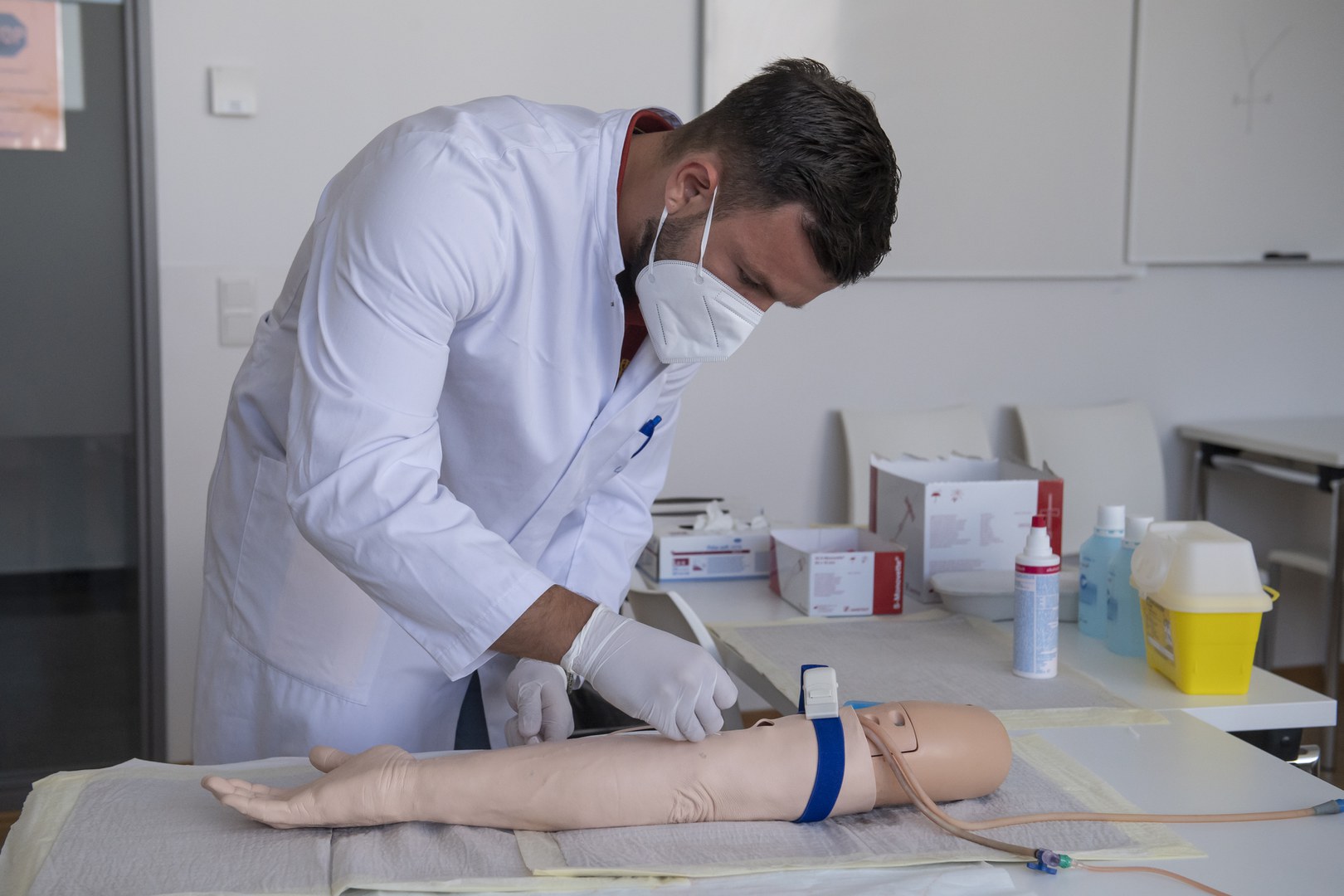 Ein Medizinstudent untersucht während der Prüfung einen Arm.