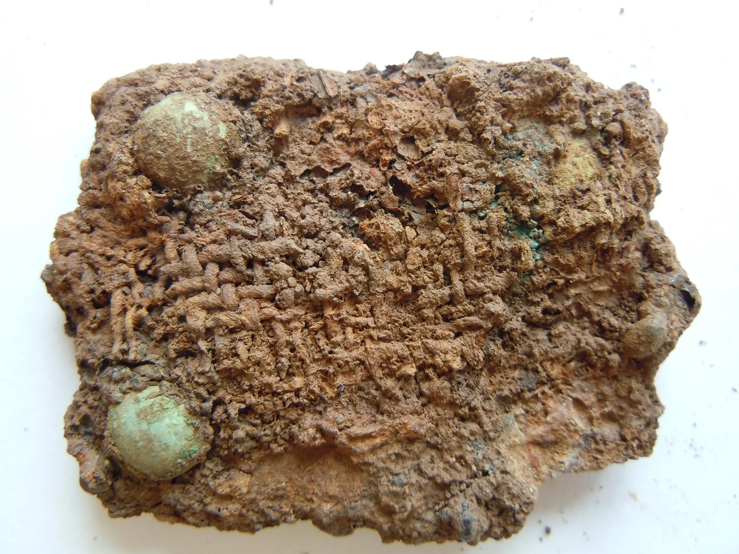 Auf diesem Gürtelbeschlag, der in Euskirchen Weidesheim gefunden wurde, finden sich gut erkennbar die Reste eines Gewebes. Oftmals sind lokale Textilfunde aus der Frankenzeit nur in geringen Mengen erhalten.