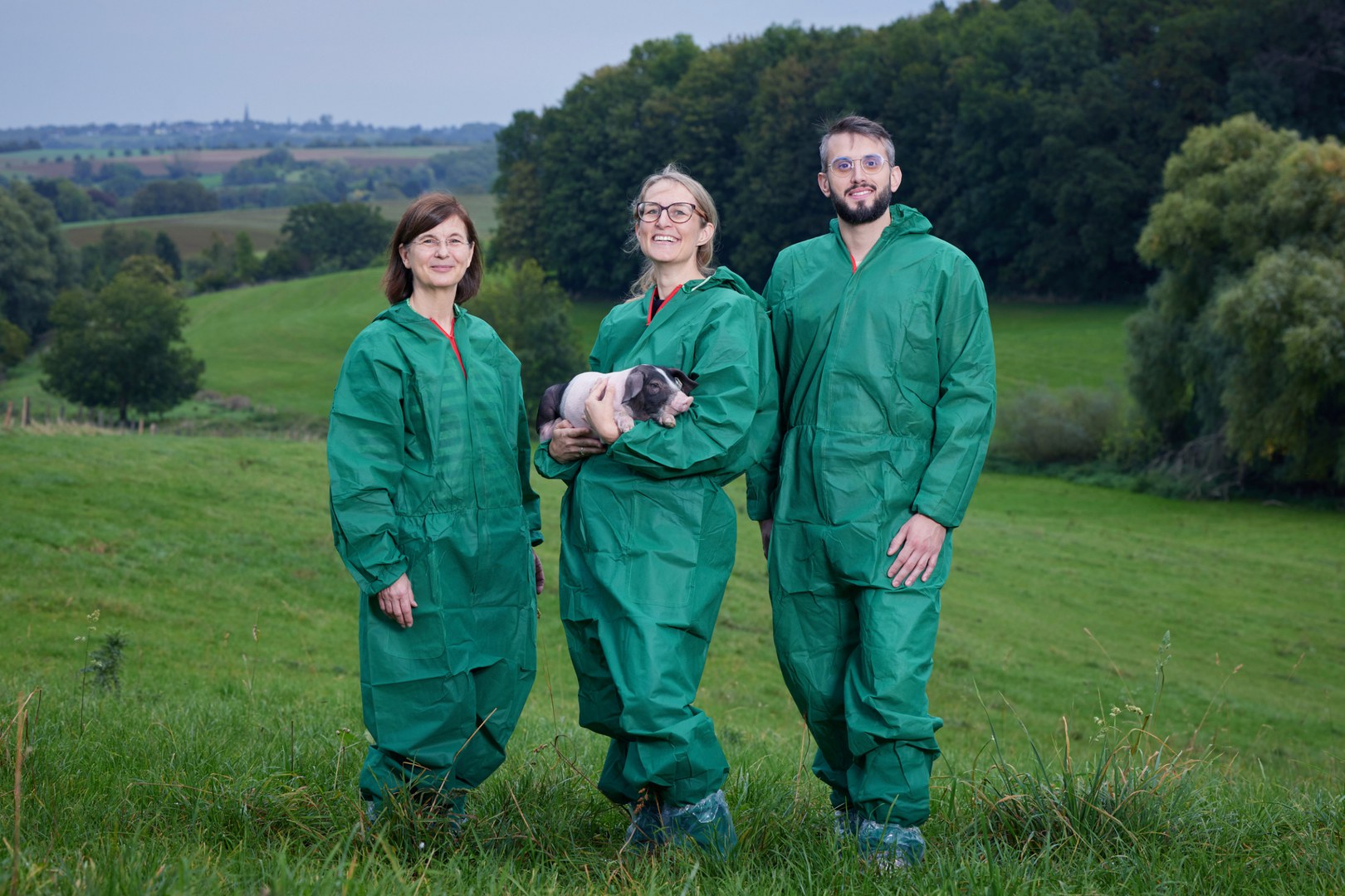 The team (left to right) in hygienic protective clothing with piglets: