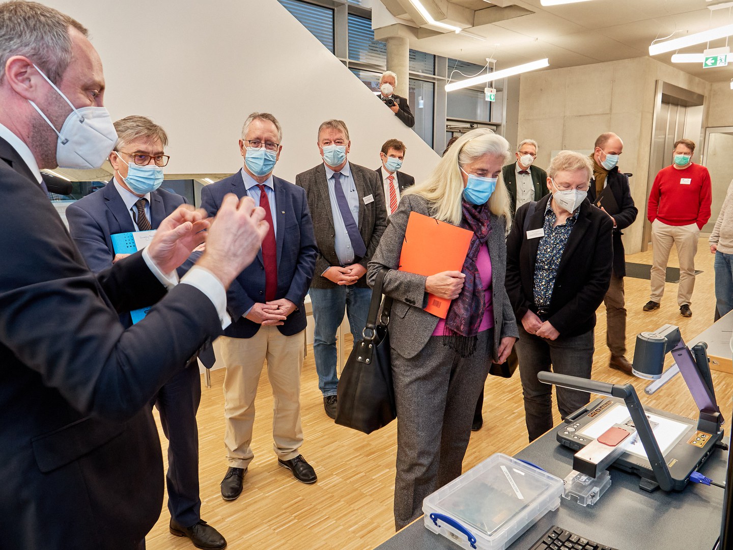 Prof. Dr. Jochen Dingfelder (right) explains to guests a component needed for detector measurements.