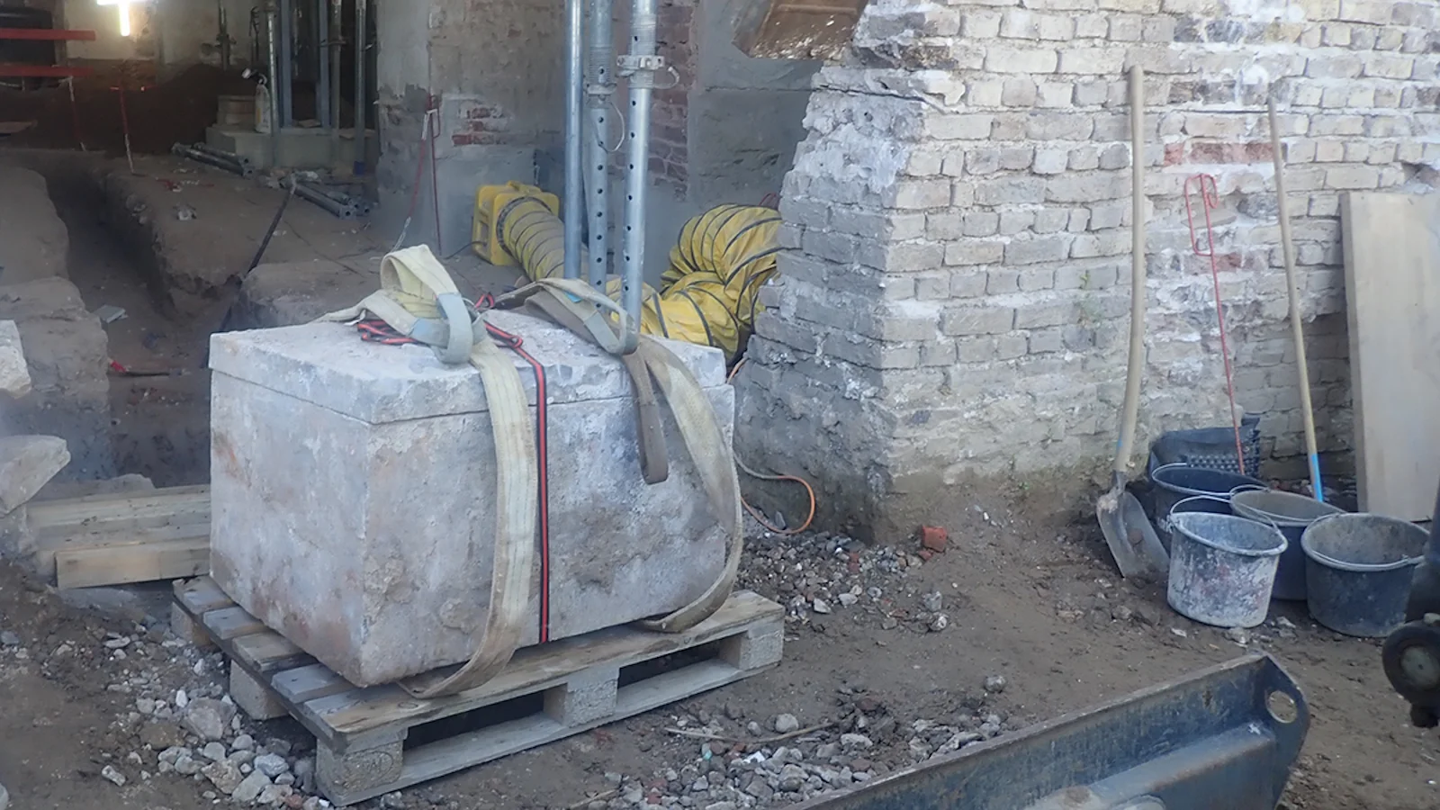The historic cornerstone, still in the middle of the construction site here, was returned to its old place after scientific examination.