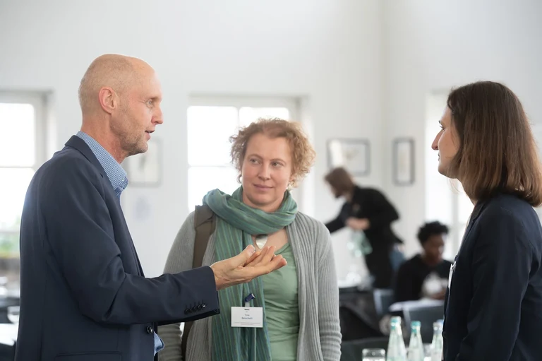 Professor Hermann Lotze-Campen from the Potsdam Institute for Climate Impact Research talking with Professor Ina Danquah and others after his lecture on the synergy effects between mitigating and adapting to climate change in the agriculture and food sector