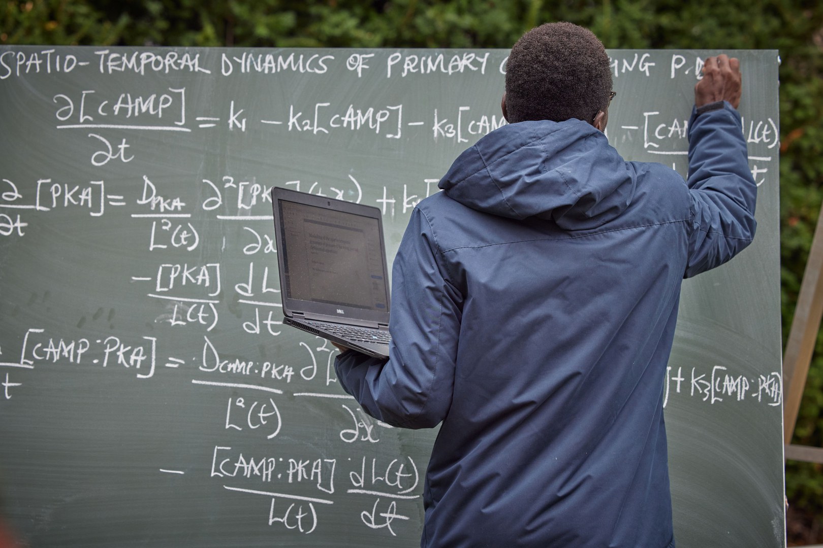 Visiting scientist Sefah Frimpong at one of the boards outside the Hausdorff Center for Mathematics building