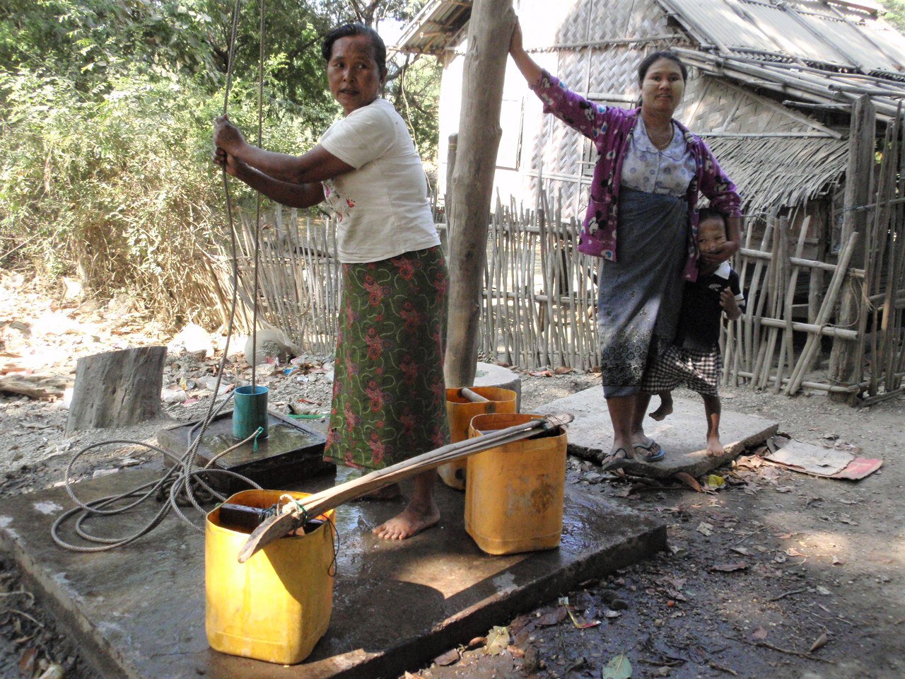 Women taking water from a ground water well in Myanmar