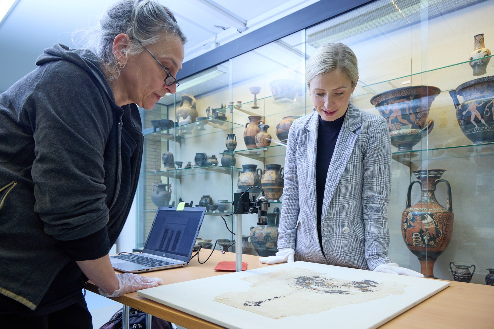 Attempting to reconstruct everyday life 1,500 years ago: Dr. Petra Linscheid and Dr. Katarzyna Lubos study a find—a piece of Egyptian fabric