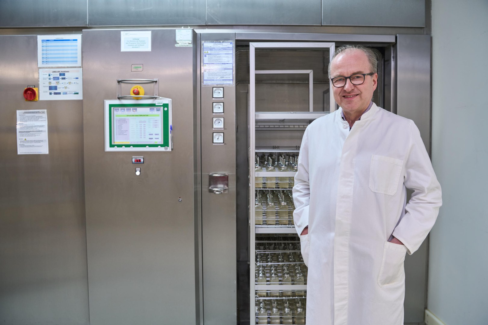 Prof. Waldemar Kolanus in front of one of the large sterilization machines, a so-called autoclave.